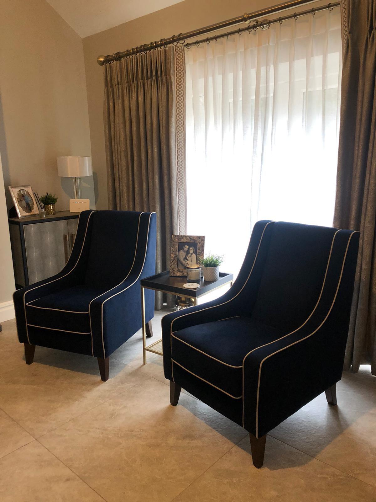 Pair of navy piped accent armchairs in a bright room